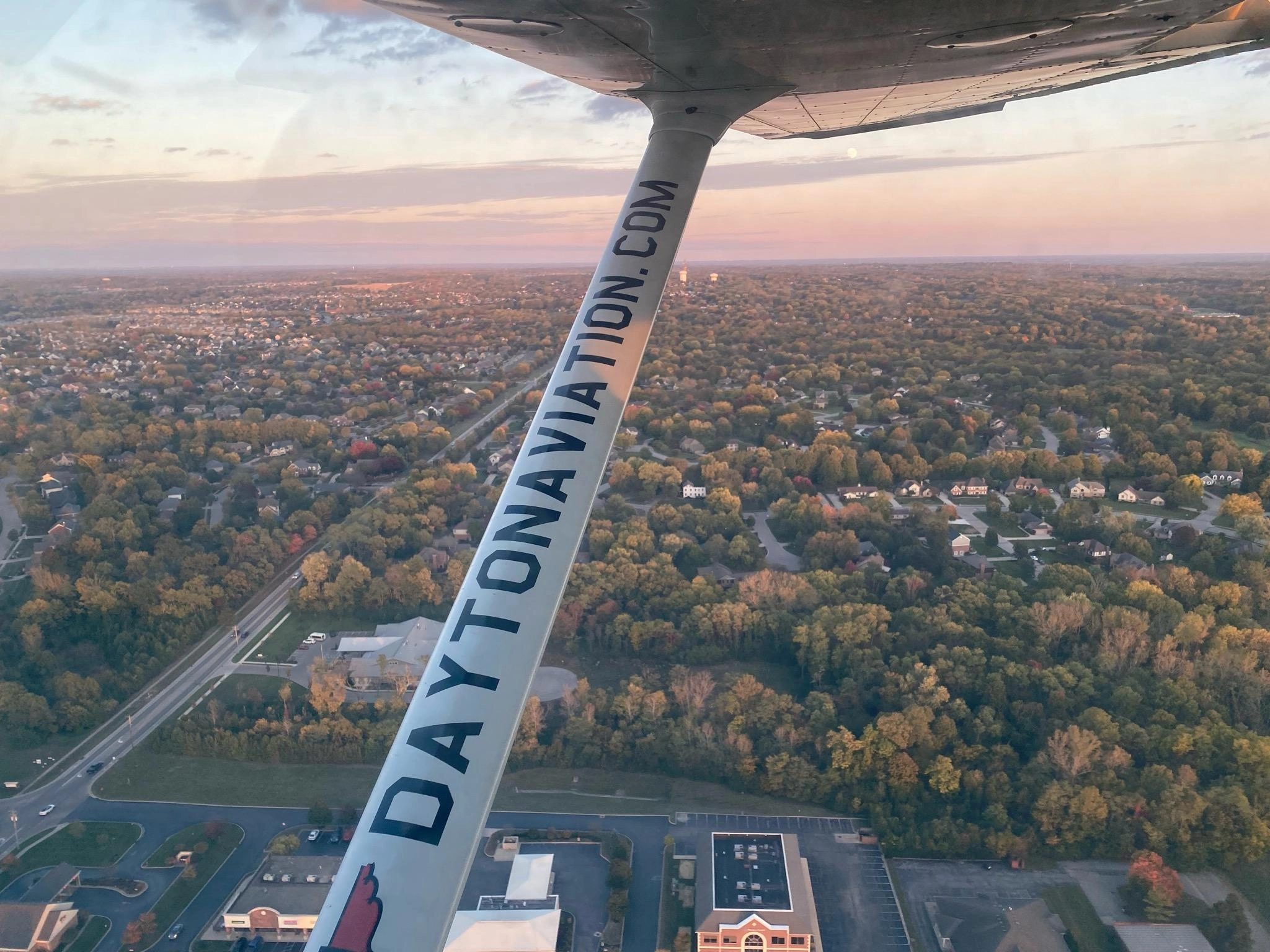Airplane wing over the city at dusk for the ${COMPANY_NAME} blog