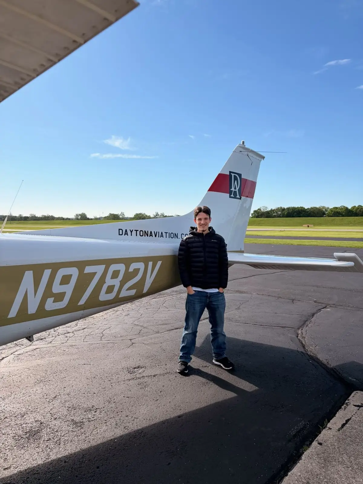 Returning pilot standing beside an aircraft tail before a flight review at Moraine Airpark