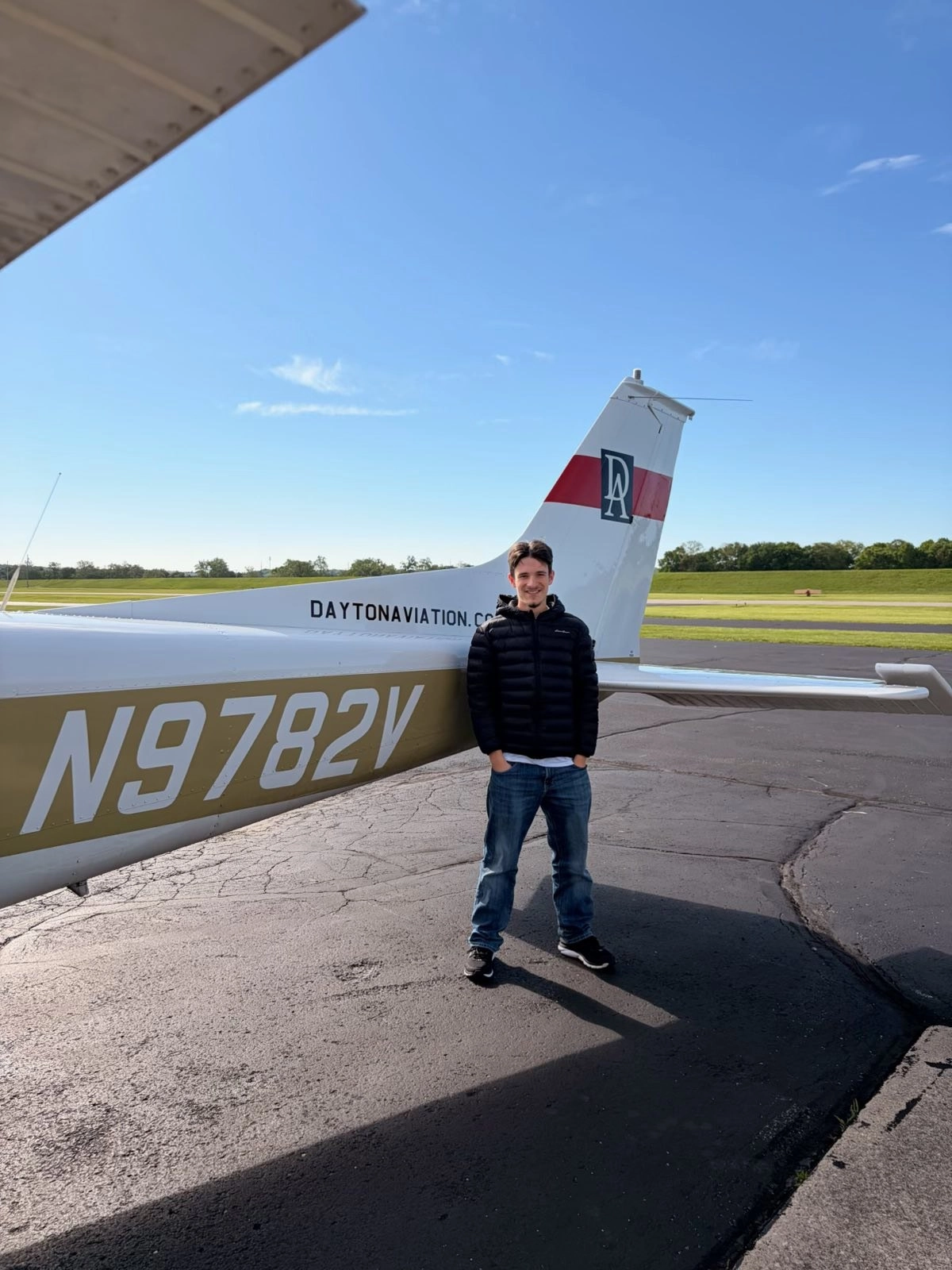 Returning pilot standing beside an aircraft tail before a flight review at Moraine Airpark