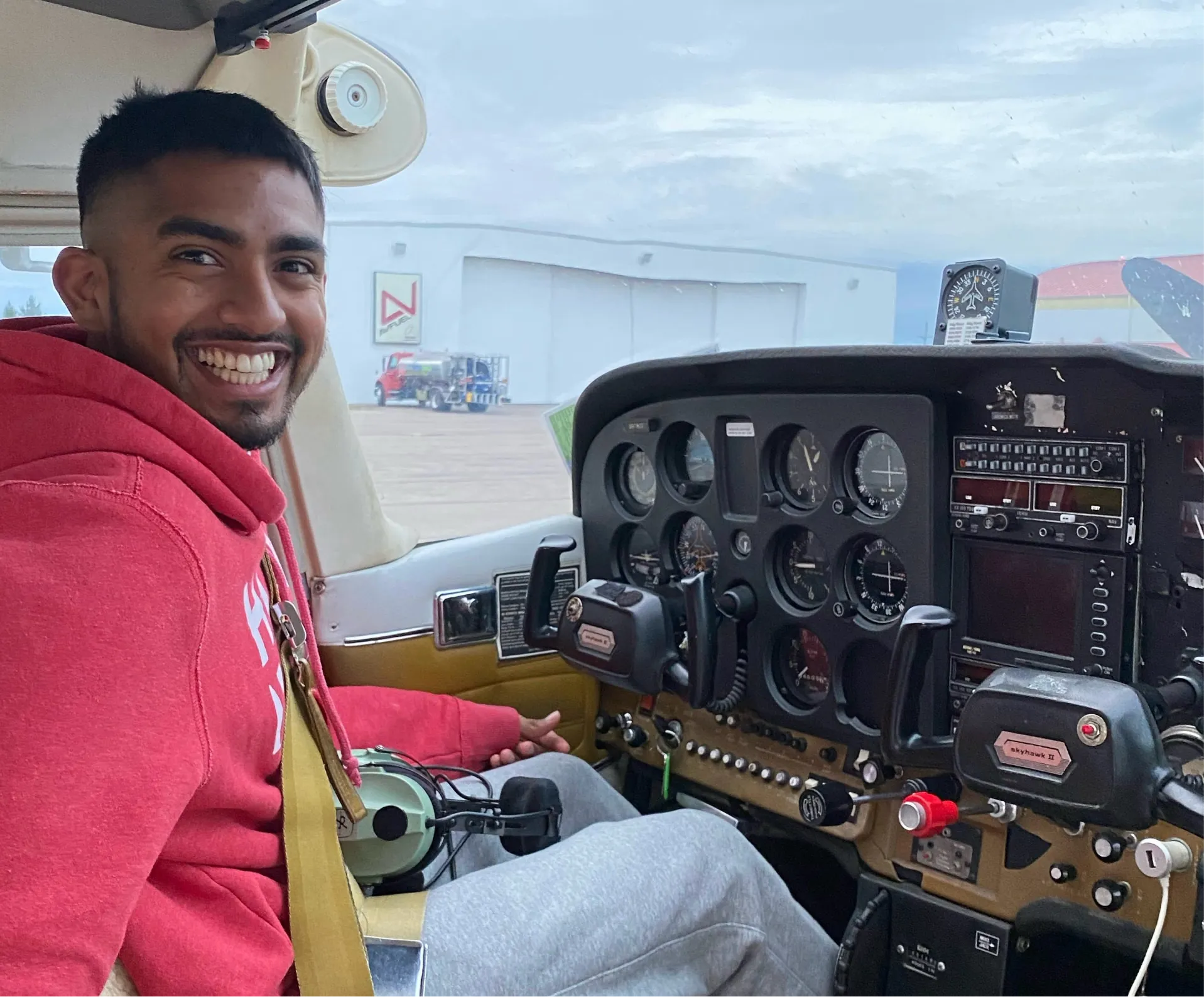 Smiling student pilot sitting in an aircraft cockpit during flight training